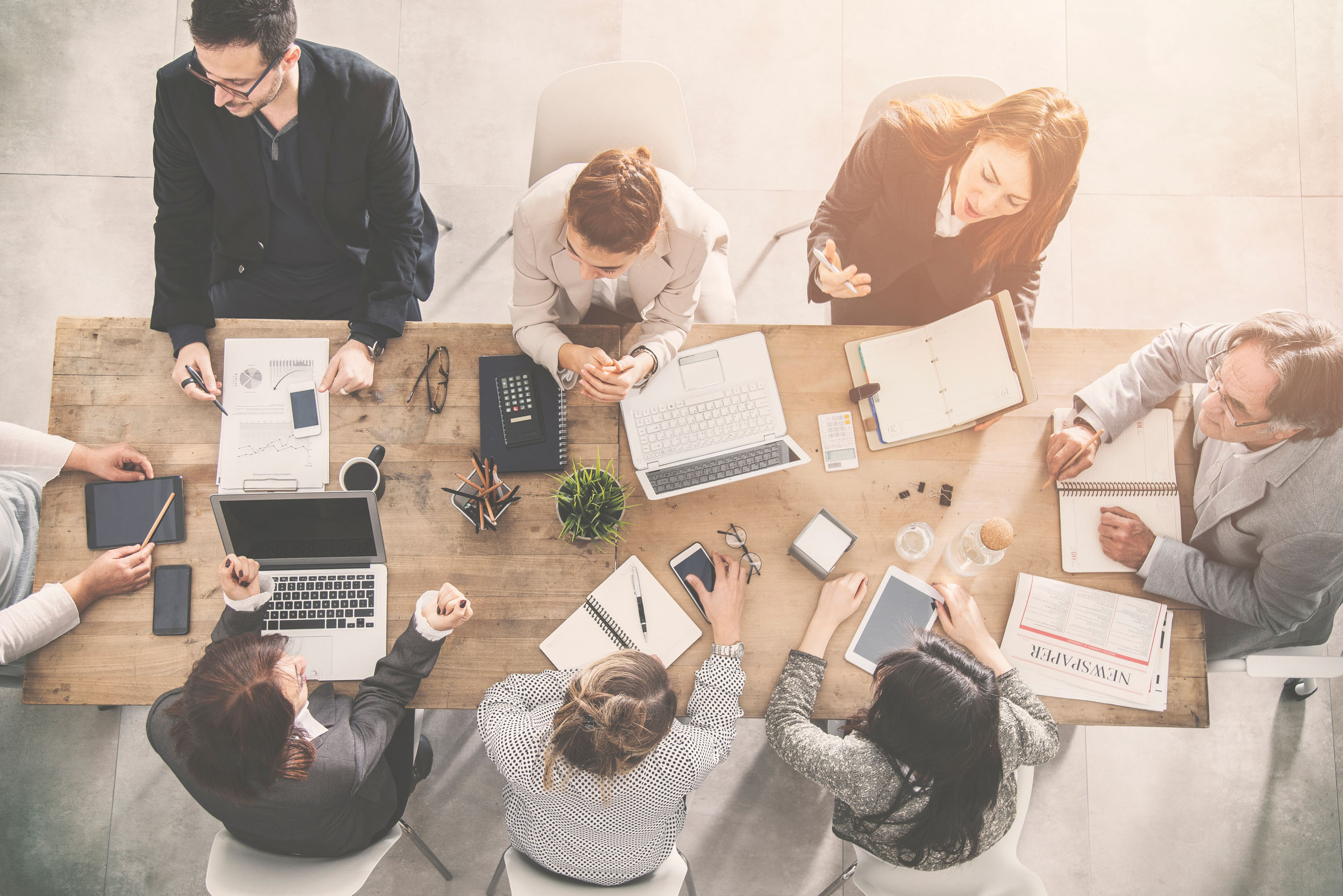 Group of people sitting round a desk working together