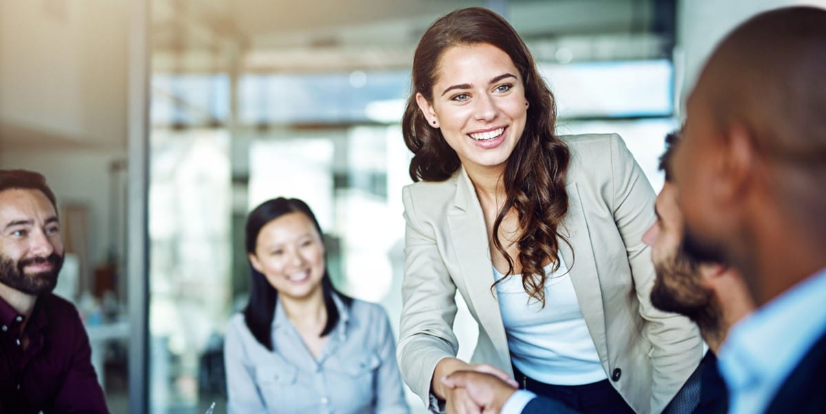 woman in office shaking hands with colleague